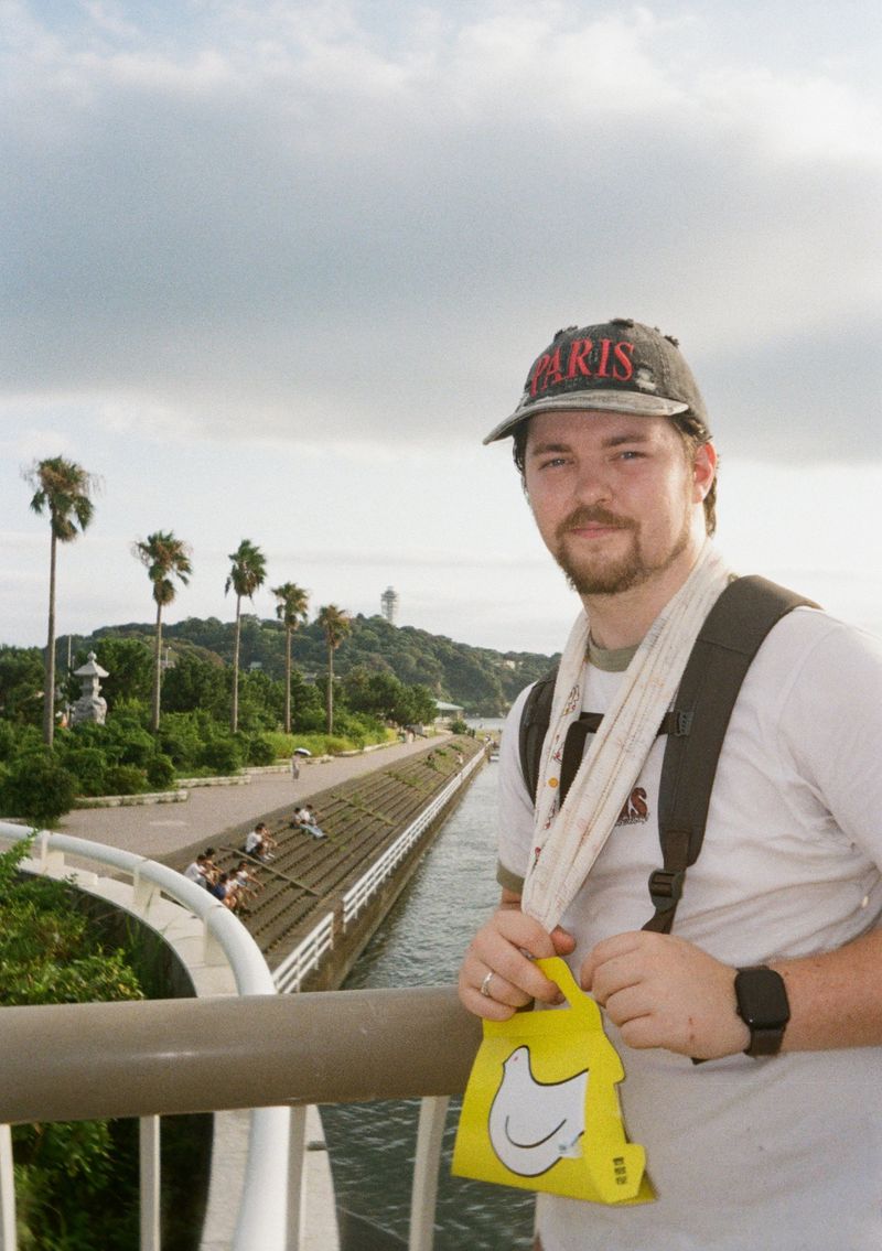 Tobias standing at a railing beside a canal
