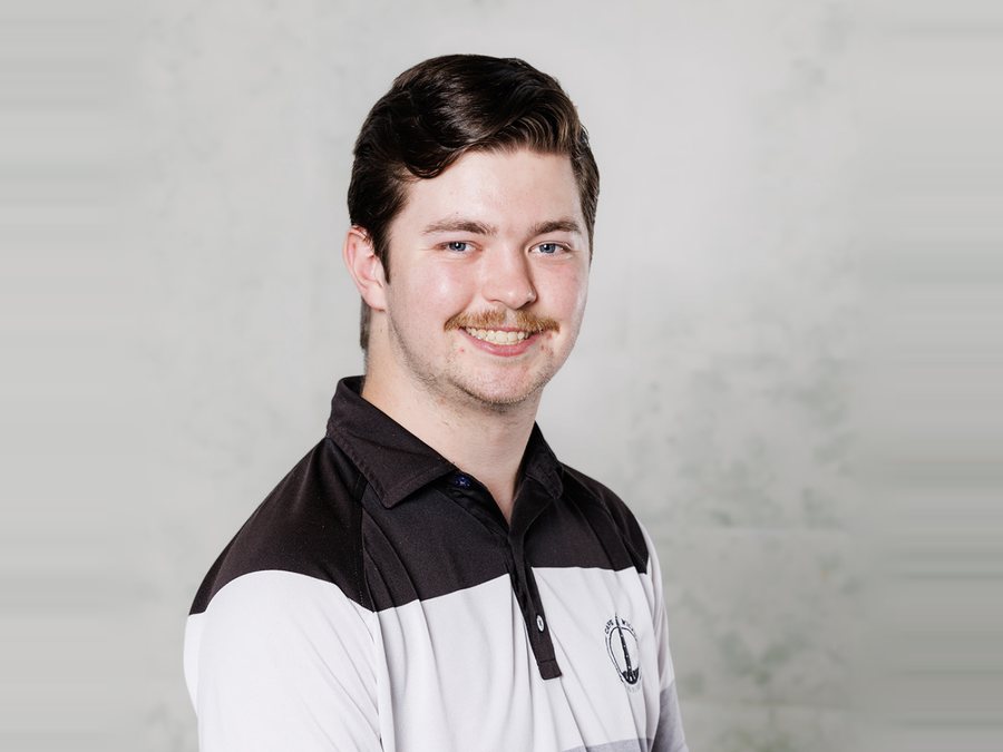 Tobias smiling in a black, white and grey striped polo shirt