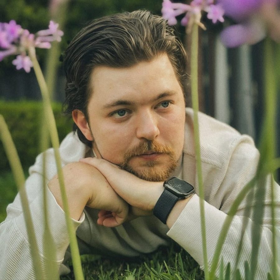 Tobias lying in a garden among purple flowers